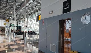 Enclosed smoking room door with cigarette sign beside Gate A67 in Brussels Airport Pier A