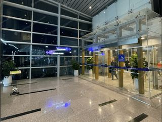 Glass-walled enclosed smoking room entrance with blue signage in Da Nang Terminal 2