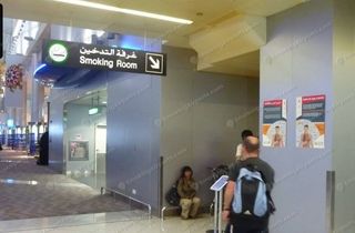 Bilingual Arabic and English smoking room sign with arrow at DXB Terminal 2
