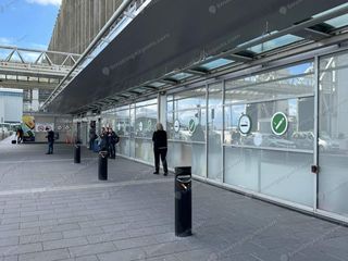 Covered outdoor landside smoking zone outside Dublin Airport terminal with green smoking icons on glass (2)