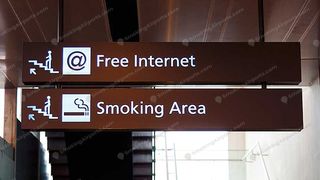 Airport directional signs pointing to Free Internet and Smoking Area