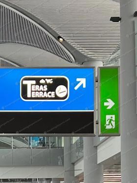 Blue overhead sign pointing to Teras Terrace smoking area inside Istanbul Airport terminal