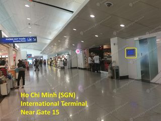 Concourse view of smoking room sign and frosted glass door near Gate 15 in SGN Terminal 2
