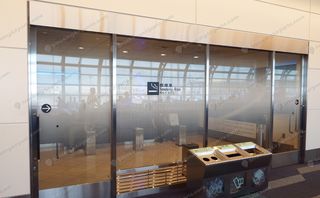 Glass-walled enclosed smoking room with bilingual signage at Haneda Airport (2)