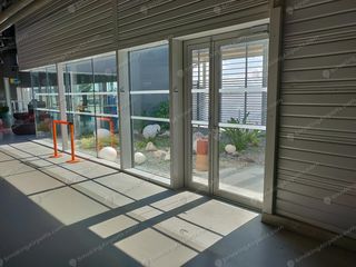Glass doors leading to outdoor smoking garden area with decorative plants and ashtray inside TLS terminal
